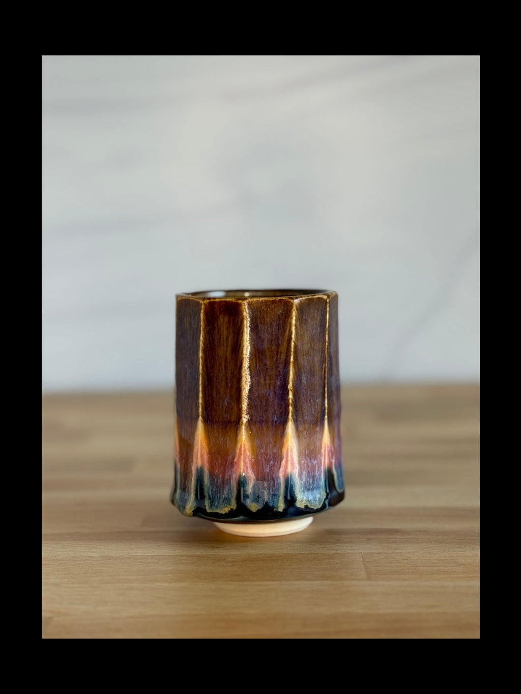 Ceramic vase with gradient glaze on a wooden surface